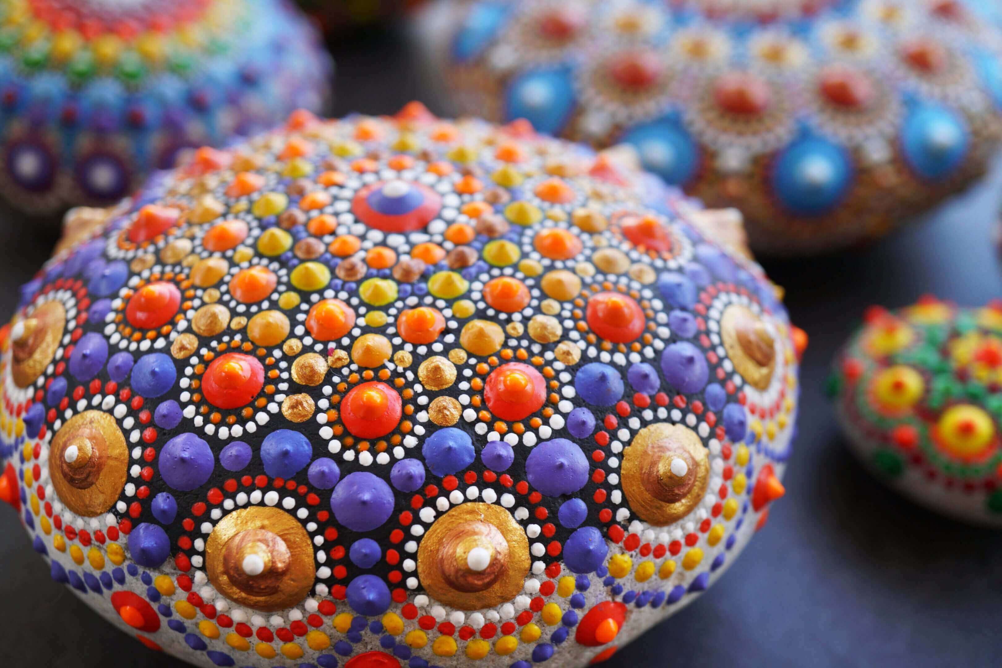 Colorful mandala stones with intricate dot patterns.