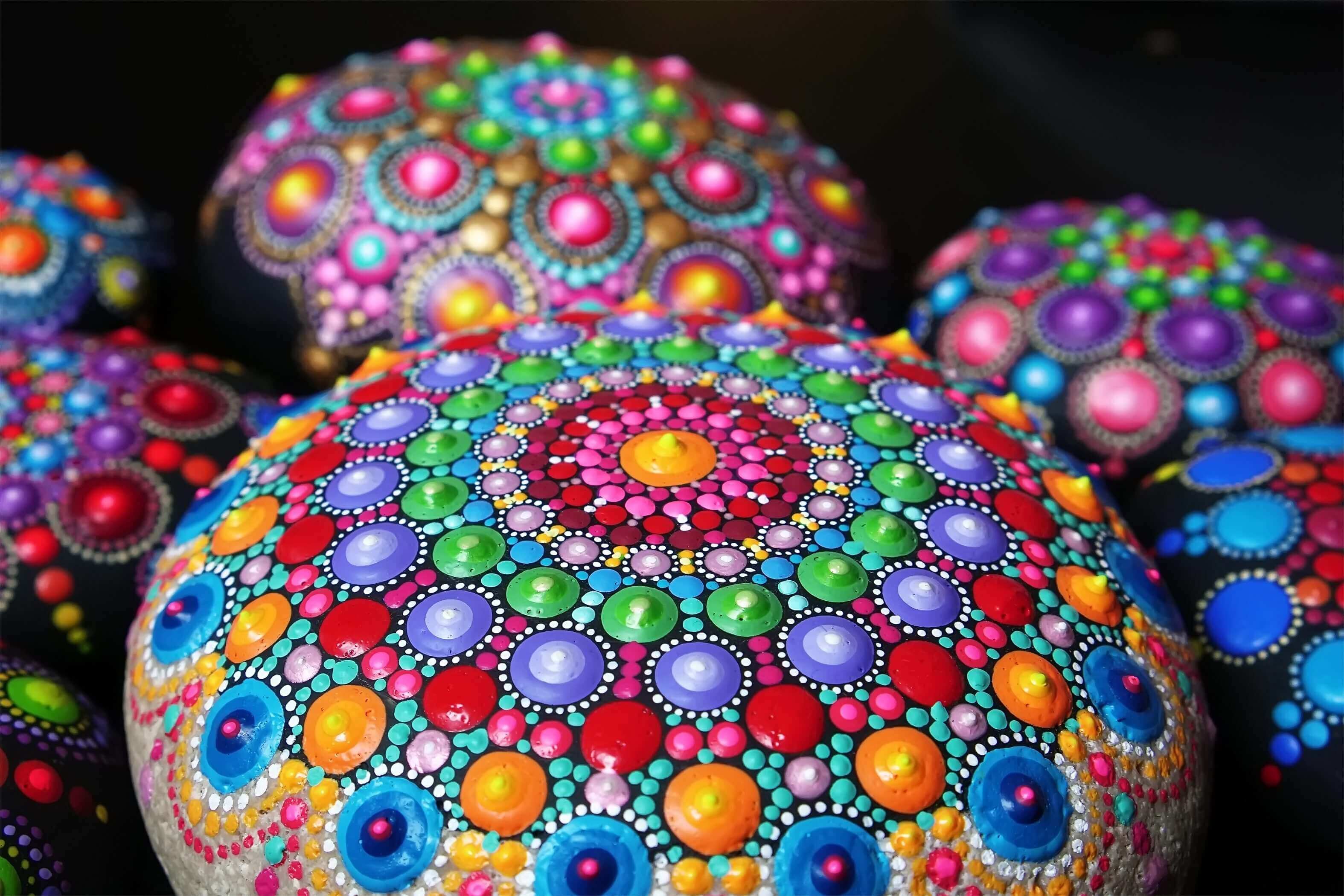 Colorful mandala stones with intricate dot patterns.