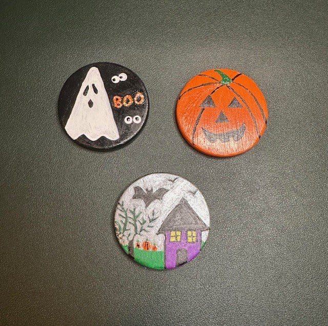 Halloween-themed painted wooden discs on display.